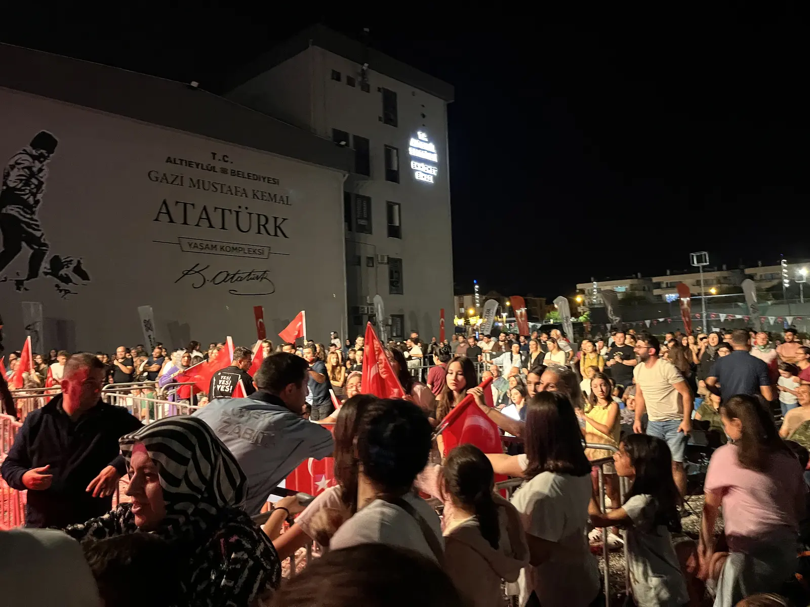 Gazi Mustafa Kemal Atatürk Yaşam Kompleksi önünde Türk bayraklarıyla konseri izleyen kalabalık — okur fotoğrafı